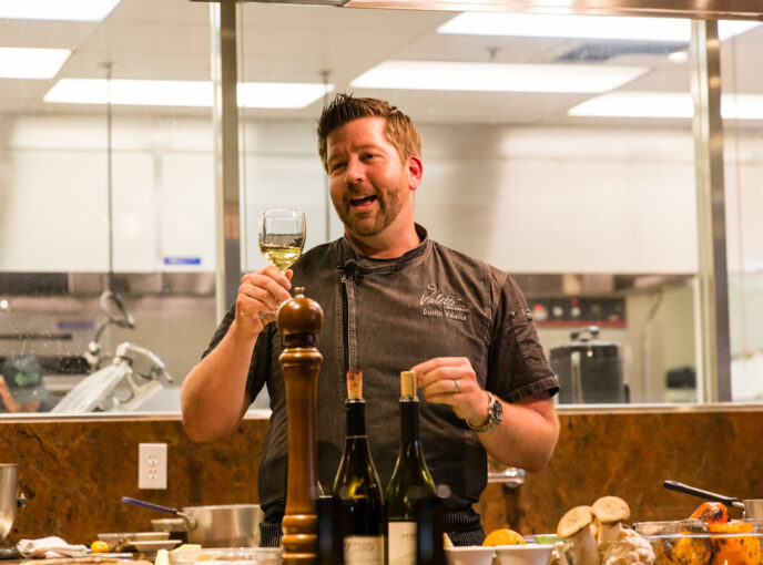 Chef Dustin with Valette toasting with a glass of white wine.