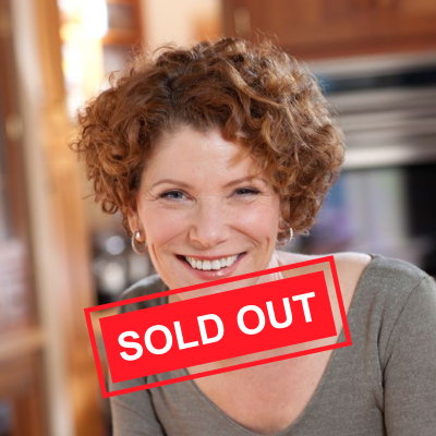 Woman with short curly red hair smiles at the camera. The words 'sold out' are superimposed.
