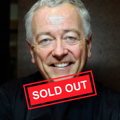 Man with gray hair and black chef coat with red lettering to say "sold out"