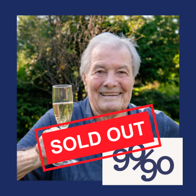 Chef in blue shirt holds glass of champagne with words "Sold Out" on top