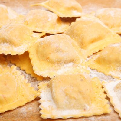 Fresh handmade ravioli on a floured board