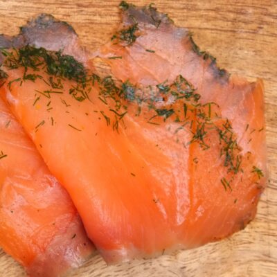 Slices of gravlax on a wooden board