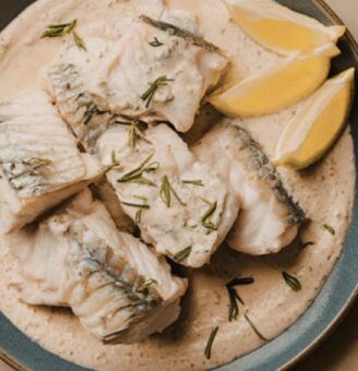 Halibut on plate with herbs and lemon