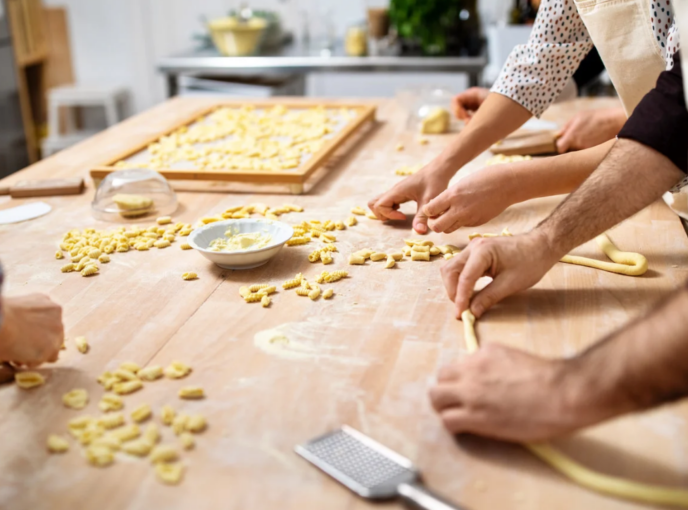 People working together at cooking counter in culinary classroom