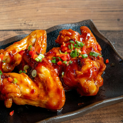 Chicken wings with spicy Thai sauce and green onions