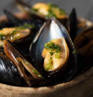 Bowl of plump mussels with herbs and broth